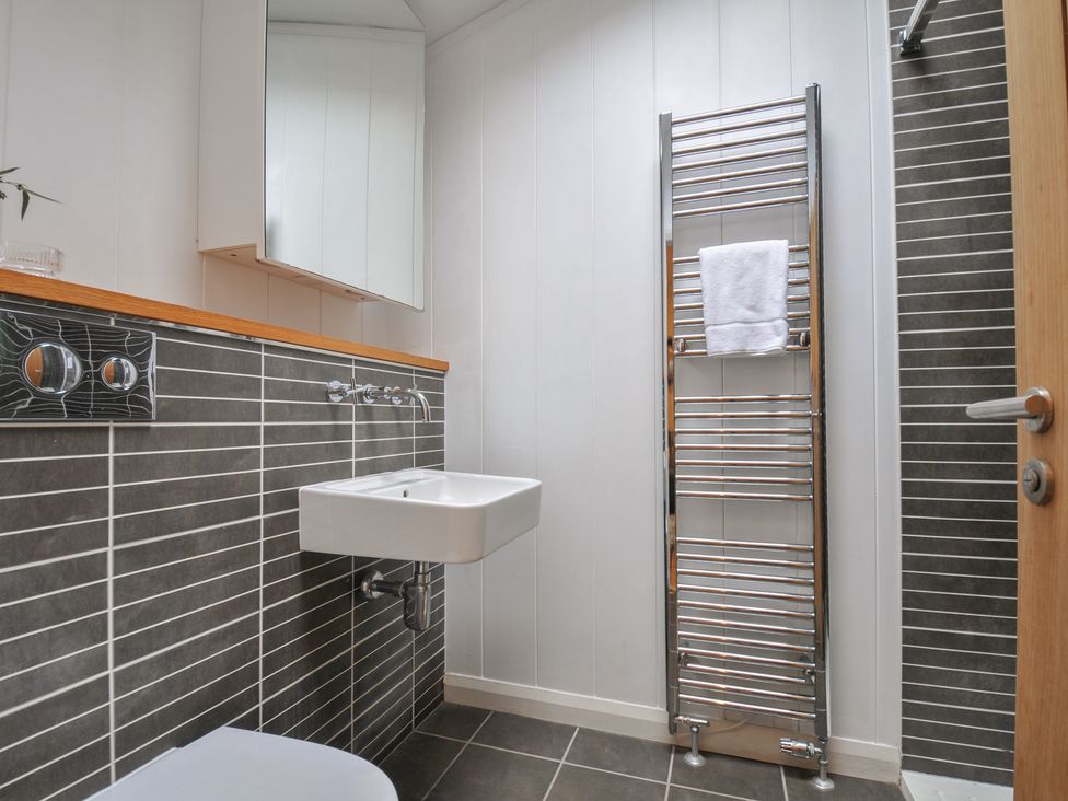 A bathroom with a wash basin and towel rack at 2 Streamside Looe