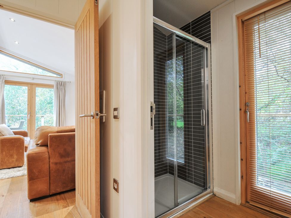 A shower and living room with a window at 2 Streamside in Looe
