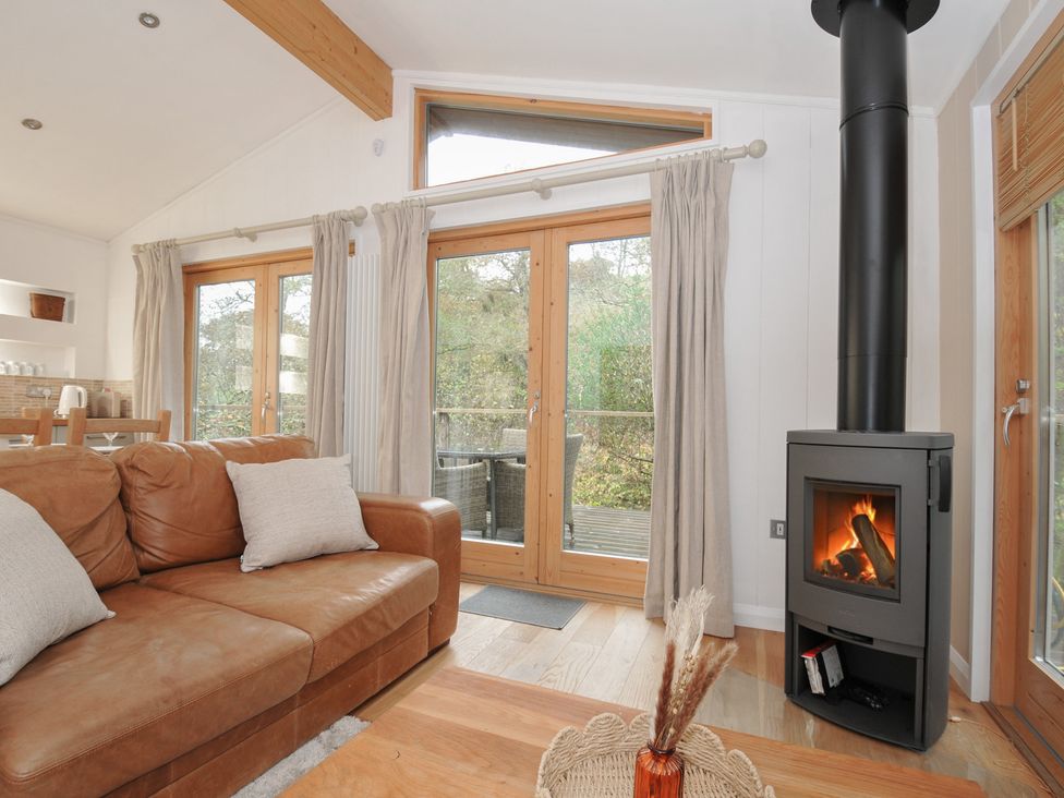 A living room with a fireplace and sofa at 2 Streamside in Lanreath