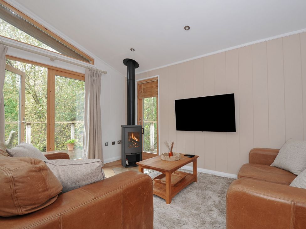 A living room with a stove and sofa at 2 Streamside in Lanreath