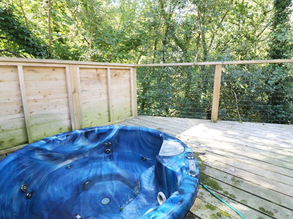 A hot tub on a wooden deck in an outdoor area at 2 Streamside Lanreath
