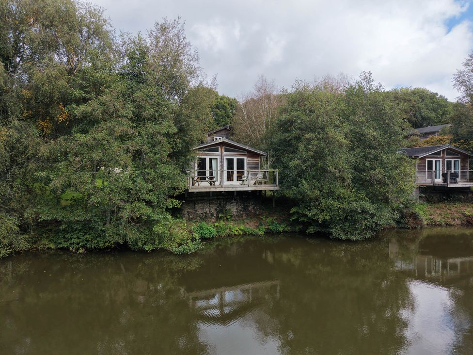 Two houses near a river with trees at 2 Water's Edge in Lanreath