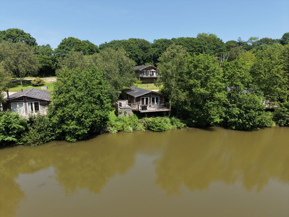 An outdoor area with cabins near a lake at 4 Water's Edge in Lanreath