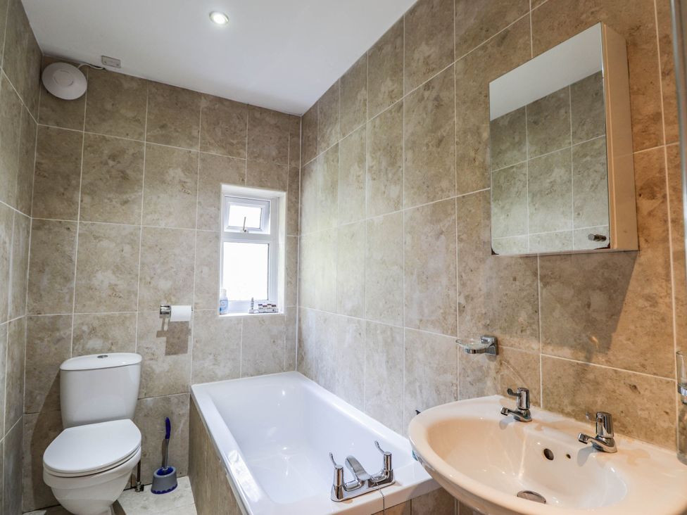 A bathroom with a toilet, bath tub, and sink at St. Aethans in Bonar Bridge