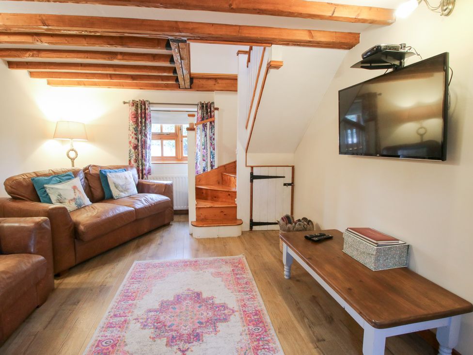 A living room with a sofa and television at Old Hall Barn 4, Church Stretton