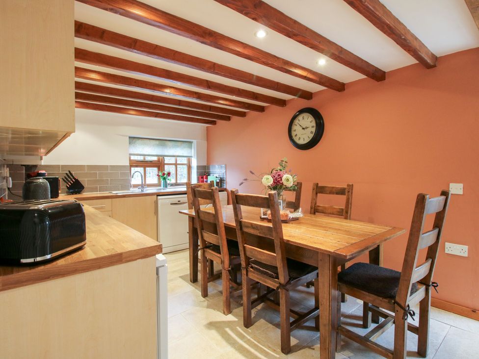 A kitchen with wooden dining table and six chairs at Old Hall Barn 4, Church Stretton