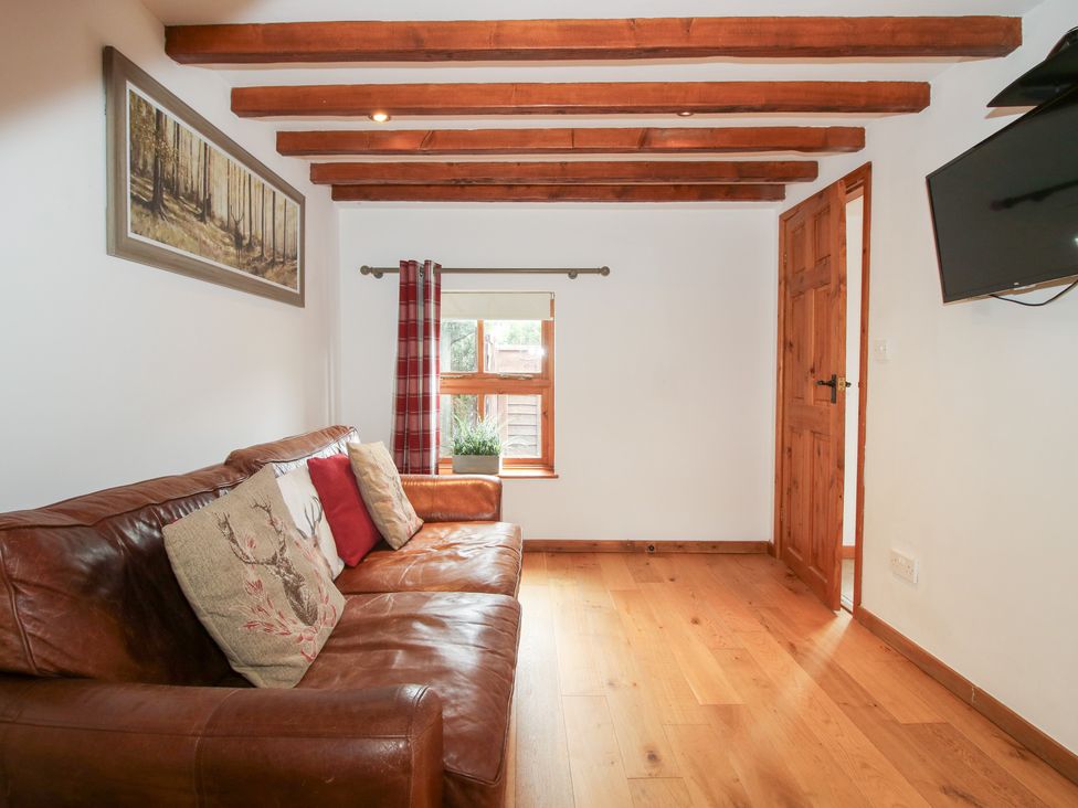 A living room with a sofa and a window at Old Hall Barn 4 Church Stretton