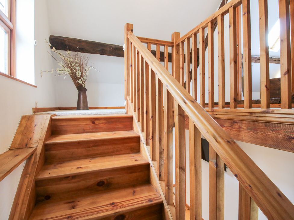 A staircase with wooden steps and banister at Old Hall Barn 4 Church Stretton