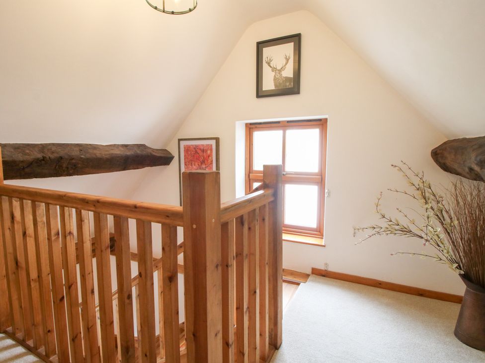 A hallway with wooden railing and window at Old Hall Barn 4, Church Stretton