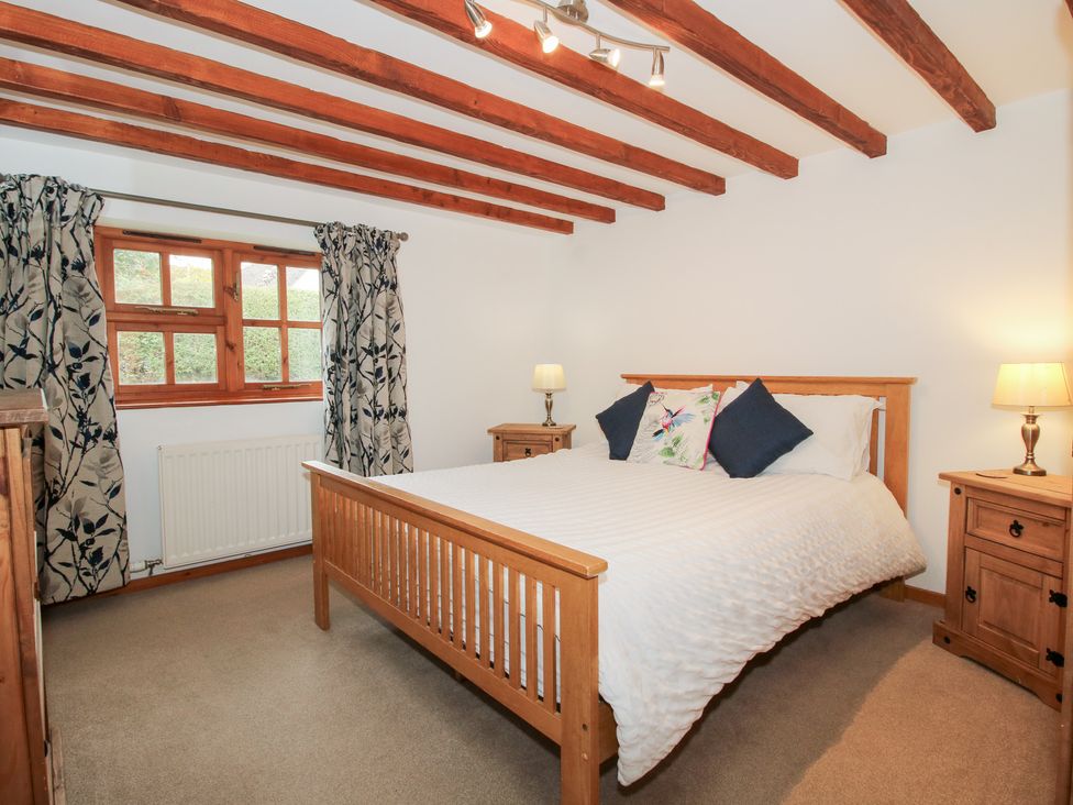 A bedroom with a bed and bedside tables at Old Hall Barn 4 in Church Stretton