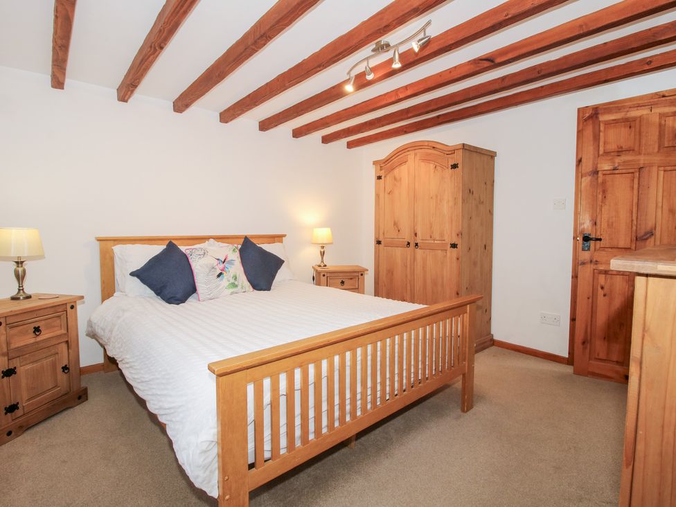 A bedroom with a bed and wardrobe at Old Hall Barn 4 Church Stretton