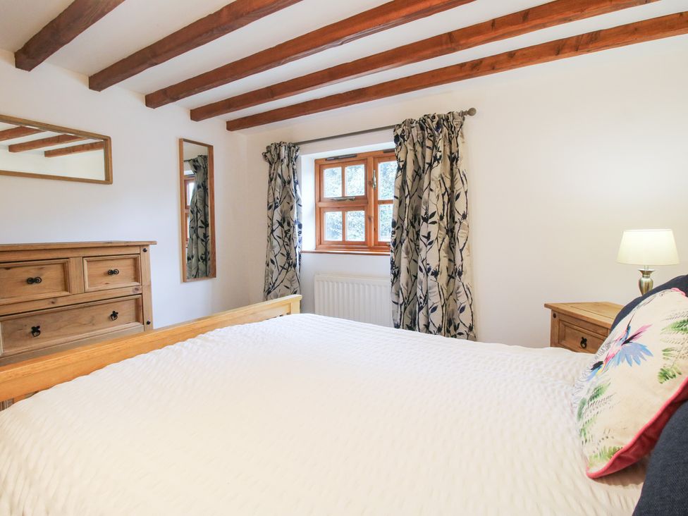 A bedroom with a bed and window at Old Hall Barn 4 Church Stretton
