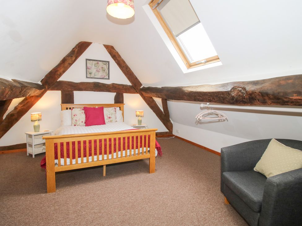 A bedroom with a bed and nightstand at Old Hall Barn 4, Church Stretton