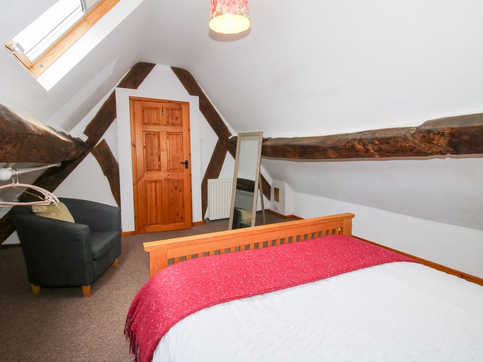 A bedroom with a bed and mirror at Old Hall Barn 4 Church Stretton
