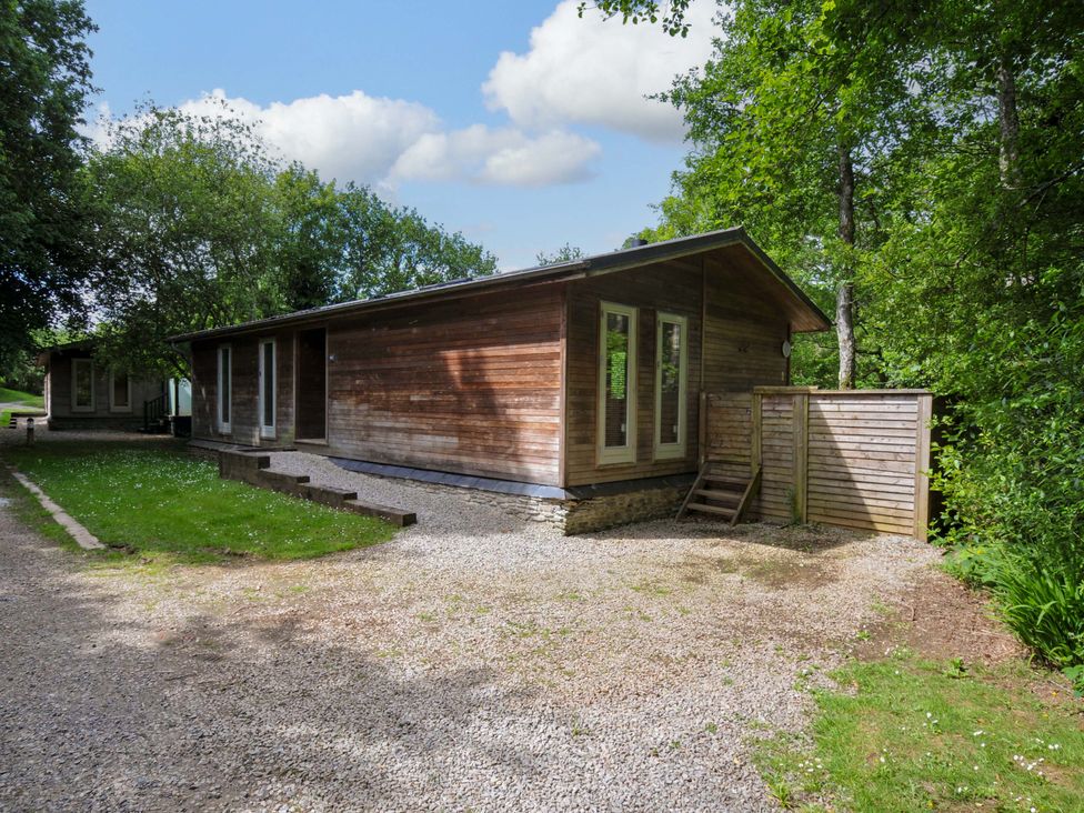 A wooden house with windows and a gravel path at 14 Stonerush Valley in Lanreath