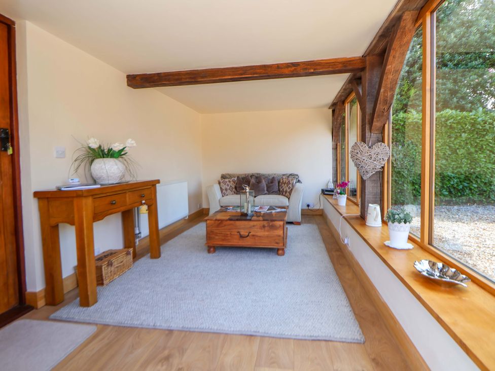 A snug with a sofa and coffee table at Honeysuckle Farmhouse in Tarporley