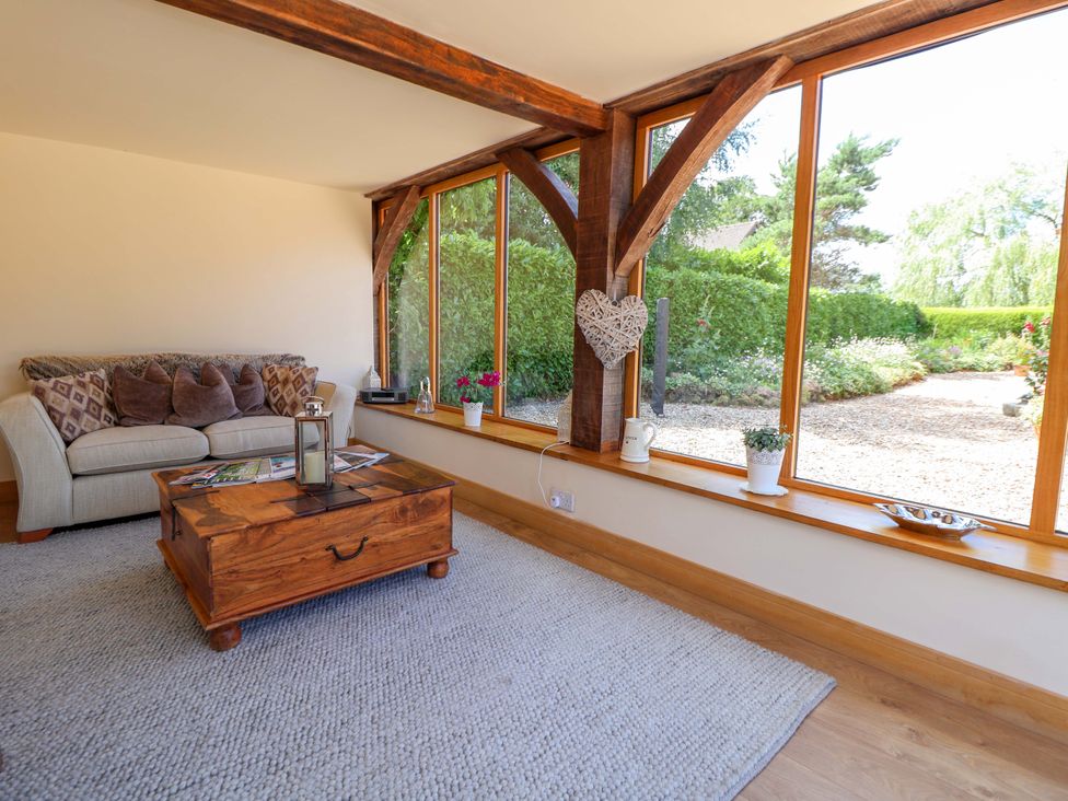 A snug room with a sofa and coffee table at Honeysuckle Farmhouse in Tarporley