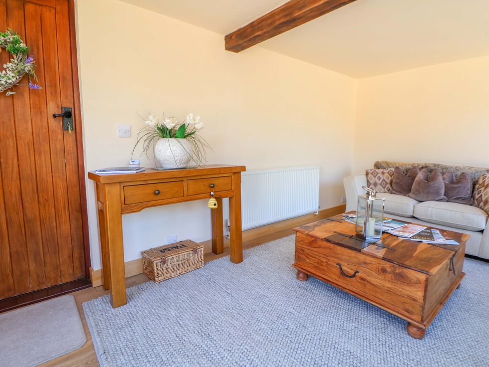 A living room with a console table and a sofa at Honeysuckle Farmhouse in Tarporley