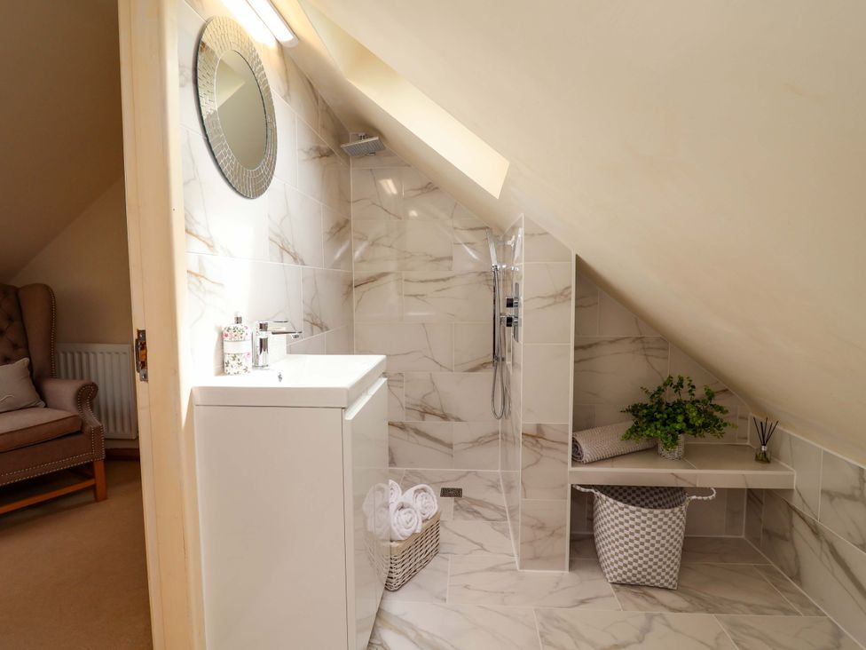 A bathroom with a shower and sink at Honeysuckle Farmhouse, Tarporley