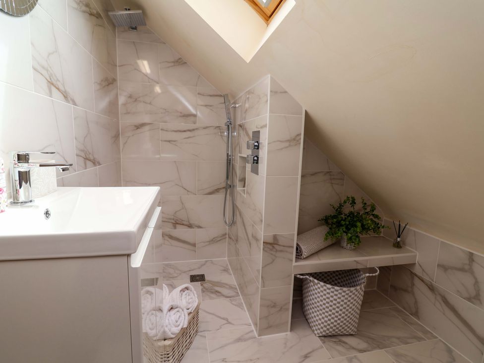 A bathroom with a shower and sink at Honeysuckle Farmhouse in Tarporley