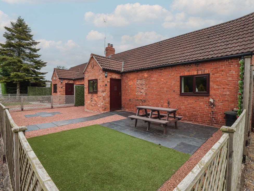 An outdoor area with a picnic table and grass at The Stable in York