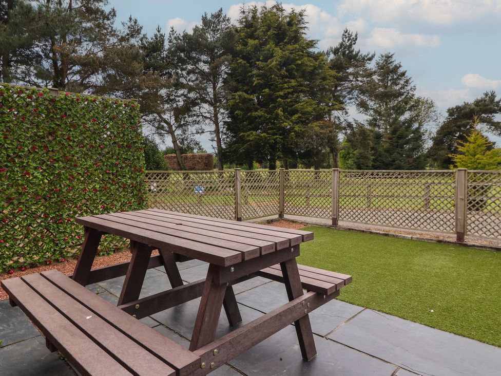 A garden with a table and benches at The Stable in York