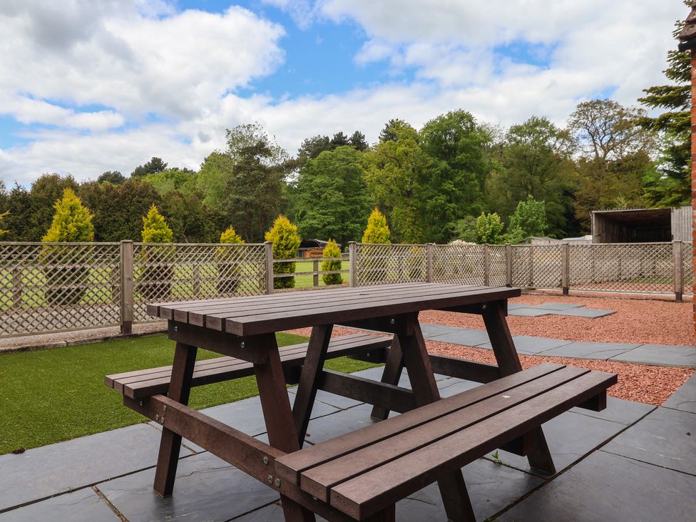 A picnic table and benches on gravel and grass at The Stable in York