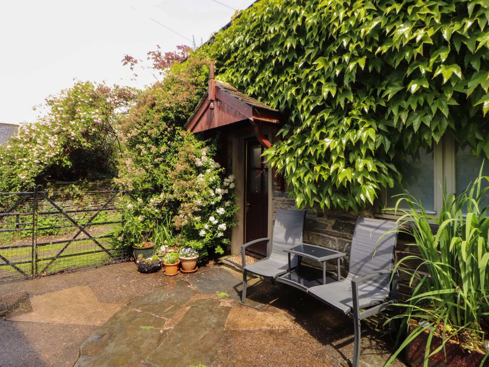 An outdoor area with chairs and a table near a door at Holemire Barn in Lorton