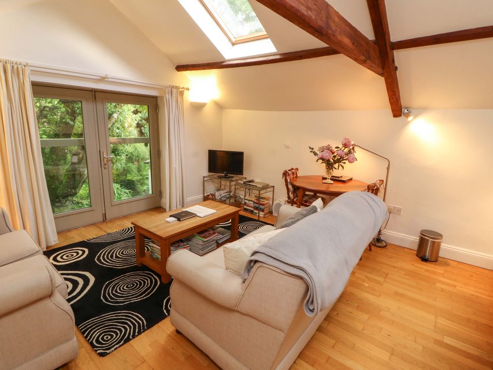 A living room with a sofa and television at Holemire Barn Lorton