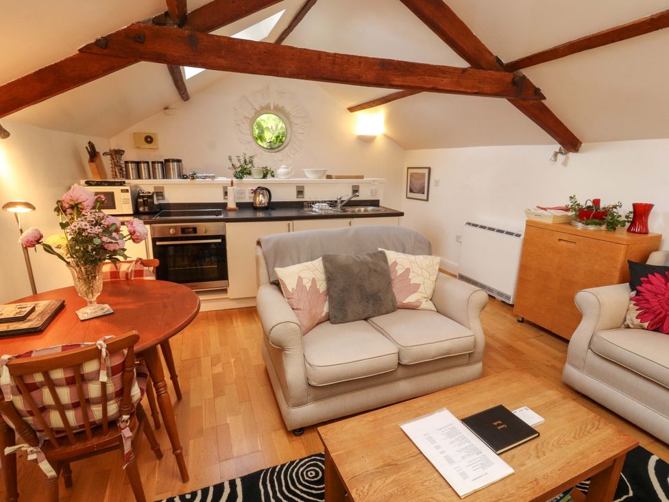 A living room with a kitchen area and dining table at Holemire Barn in Lorton
