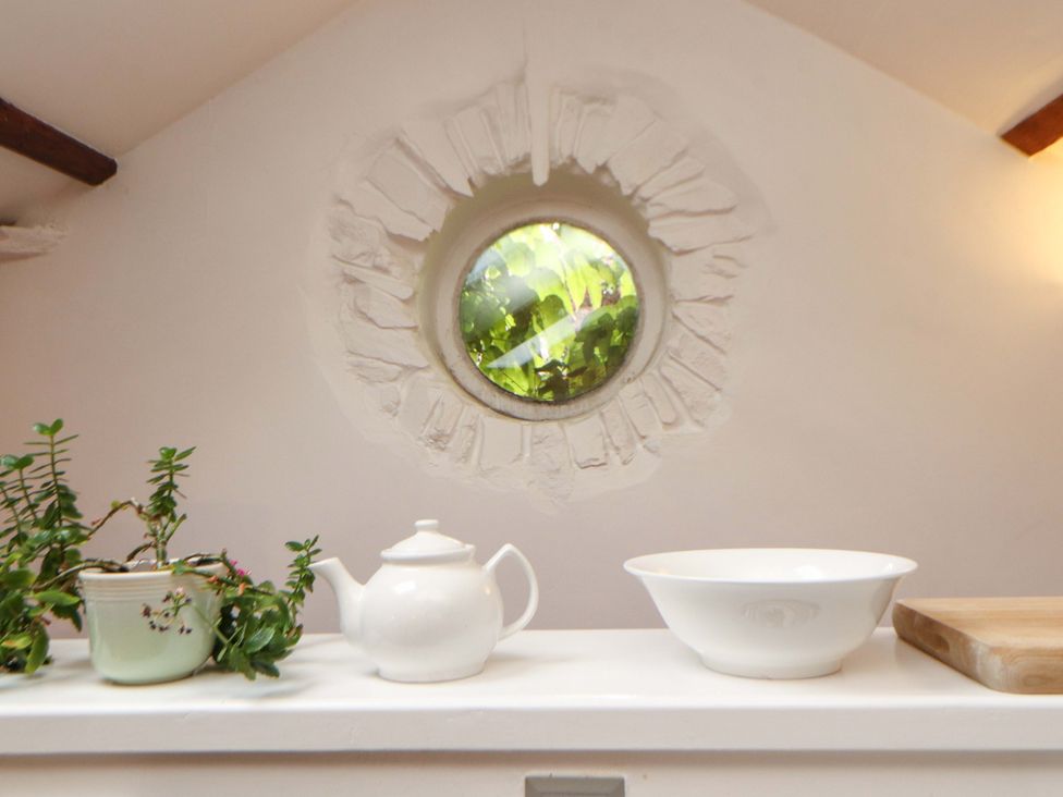 A kitchen with a window, a plant, a teapot, a bowl, and a cutting board at Holemire Barn in Lorton