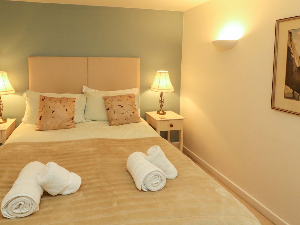 A bedroom featuring a bed with cushions and lamps at Holemire Barn in Lorton
