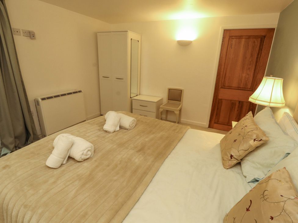 A bedroom with a bed and a chair at Holemire Barn Lorton