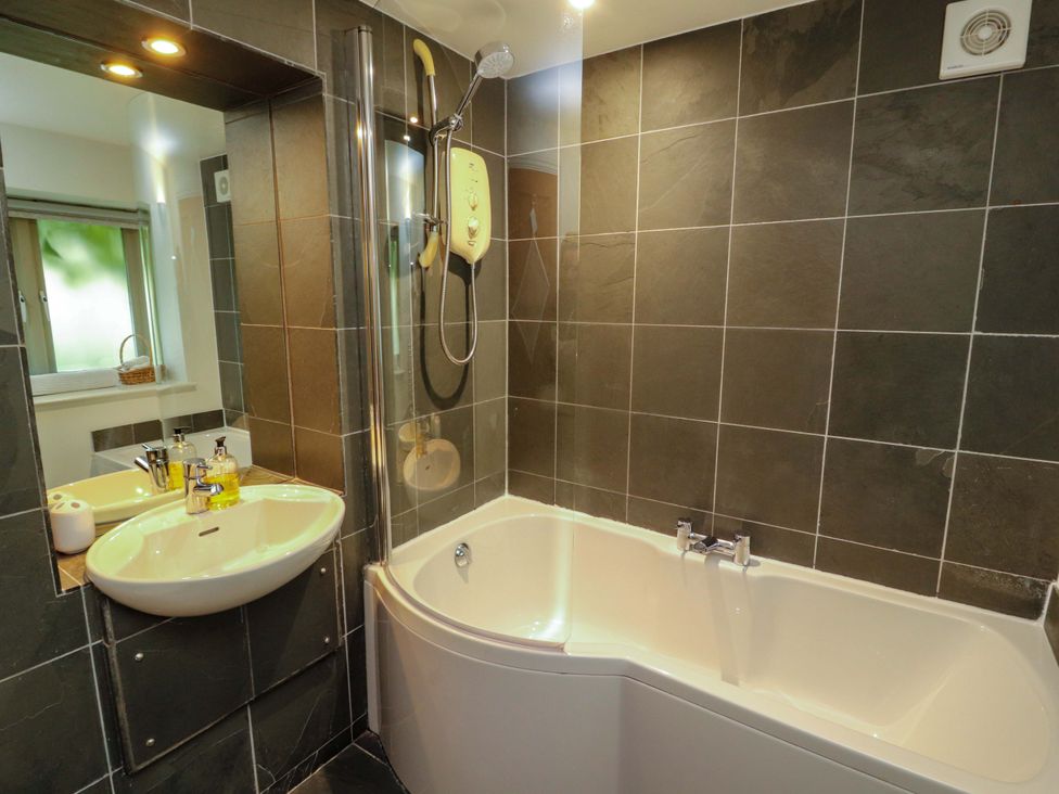 A bathroom with a bathtub and shower at Holemire Barn in Lorton
