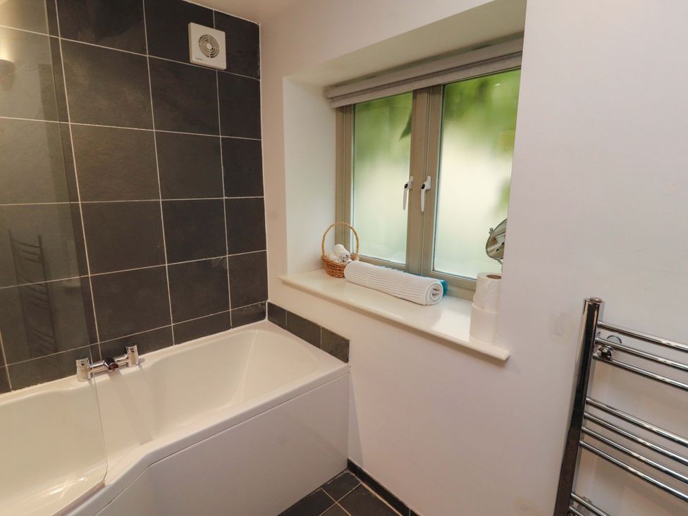 A bathroom with a bathtub and window at Holemire Barn in Lorton
