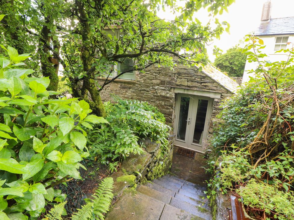 An outdoor view of a stone building surrounded by plants at Holemire Barn Lorton
