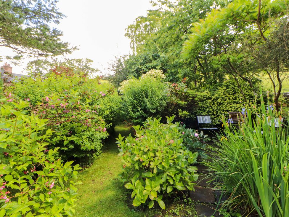 A garden with plants and a pathway at Holemire Barn in Lorton