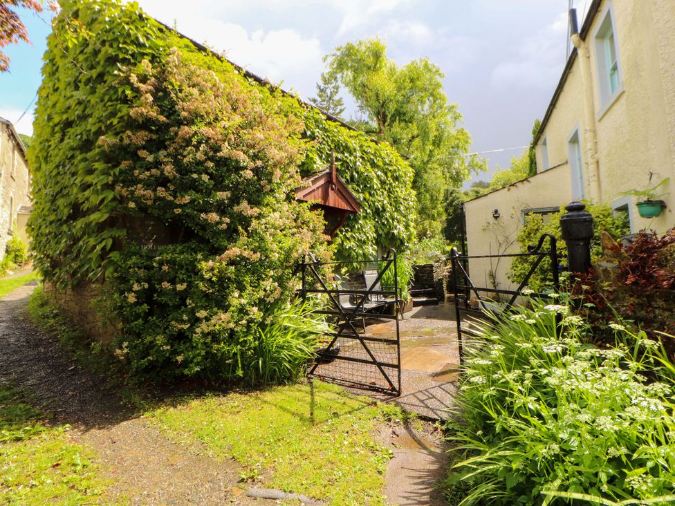 A garden with a gate and pathway at Holemire Barn in Lorton