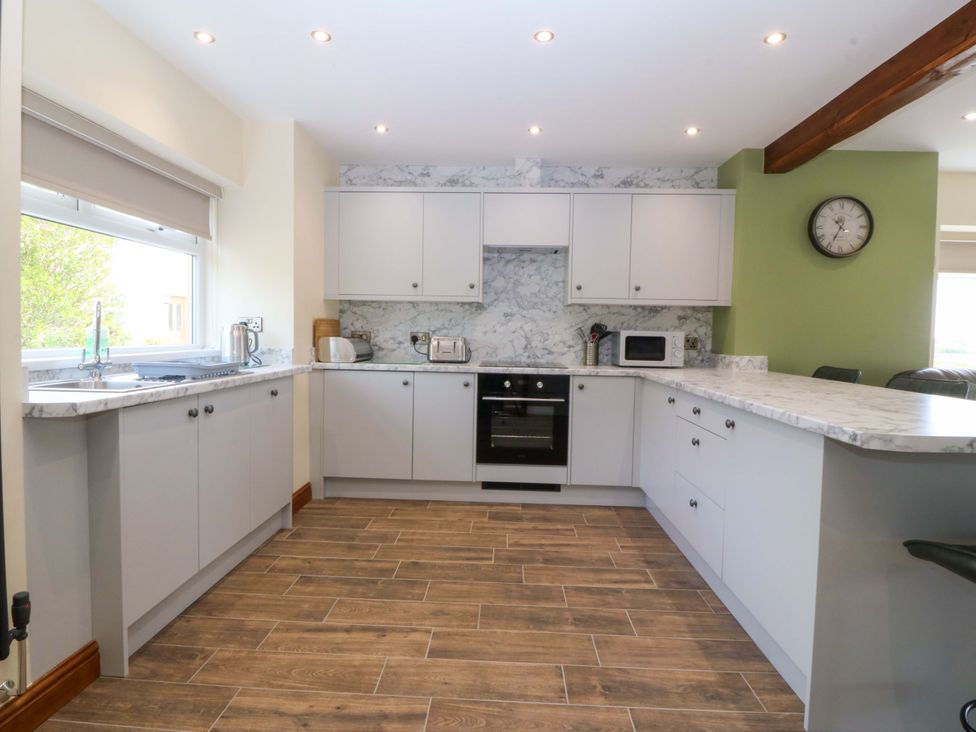 A kitchen with cabinets and appliances at Dalar Deg Aberdaron