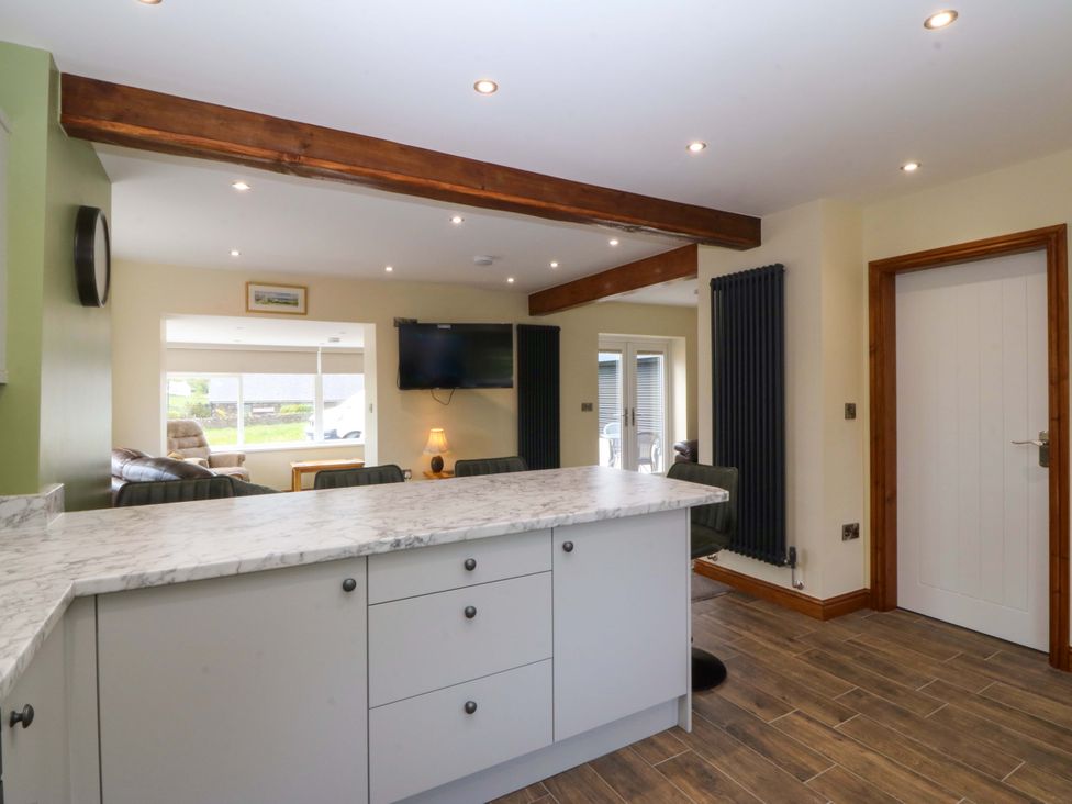 A kitchen with an island and television at Dalar Deg in Aberdaron