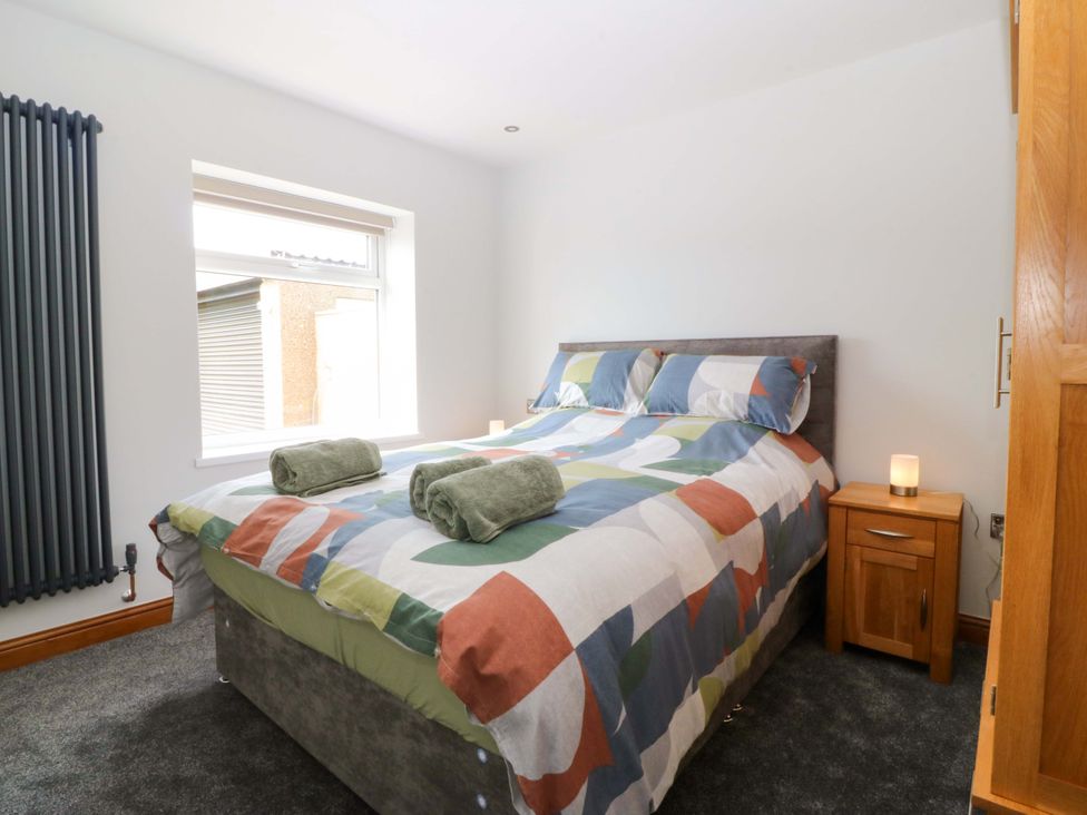 A bedroom with a bed and nightstand at Dalar Deg Aberdaron