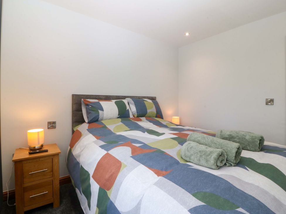 A bedroom with a bed and bedside table at Dalar Deg in Aberdaron
