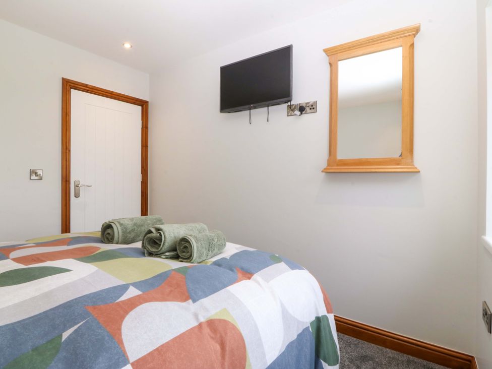 A bedroom with a bed and towels on it at Dalar Deg in Aberdaron