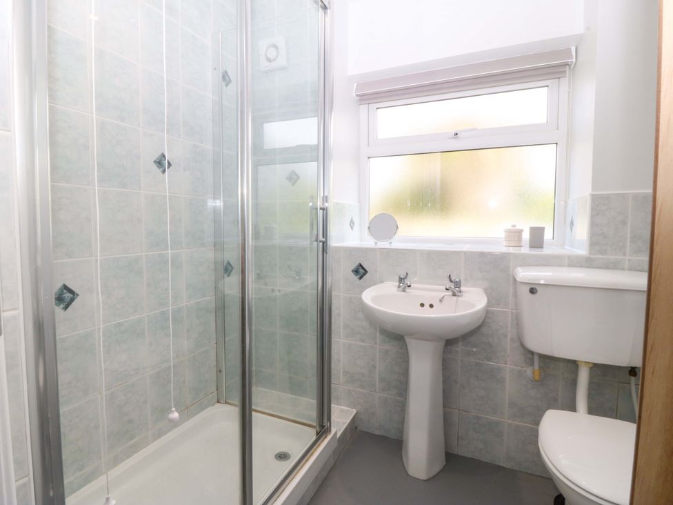 A bathroom with a shower, sink and toilet at Dalar Deg in Aberdaron