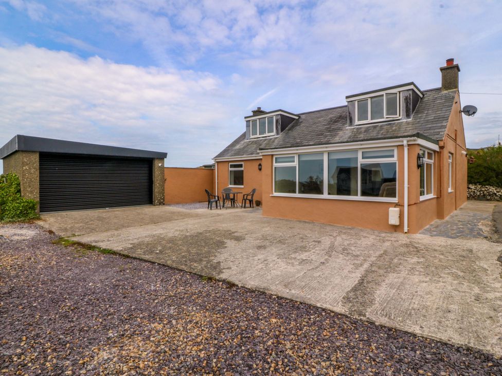 A house with a garage and seating area at Dalar Deg Aberdaron