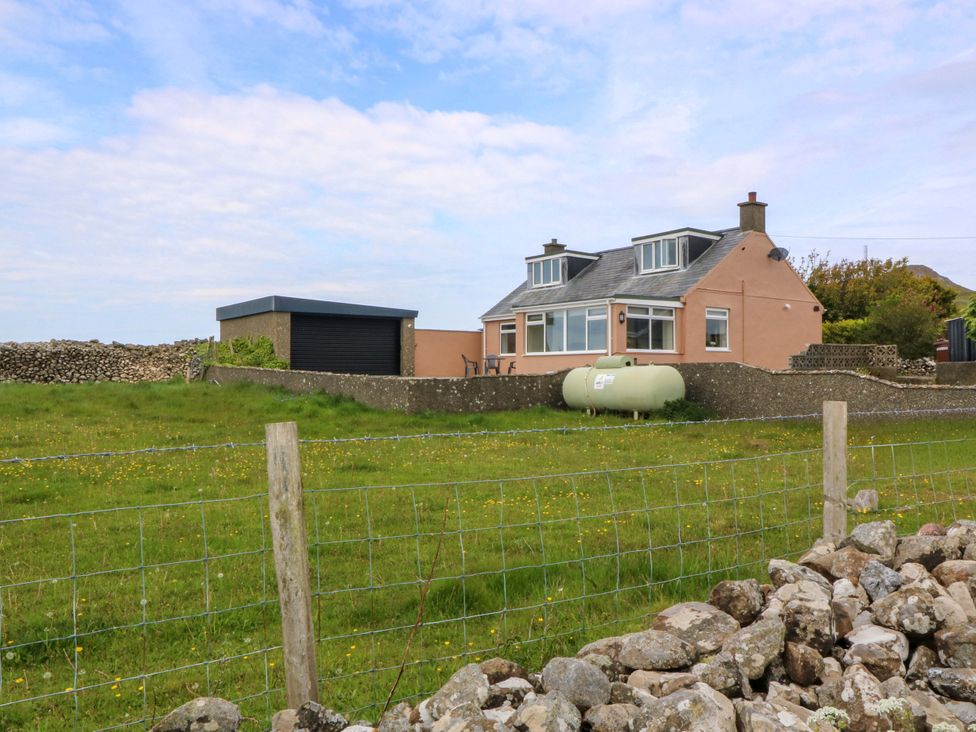 A house with a garage and lawn at Dalar Deg Aberdaron