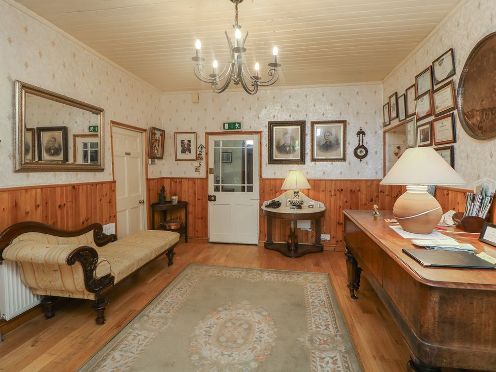 A hallway with a sofa, lamp, and desk at Cairbre House, Dungarvan, County Waterford