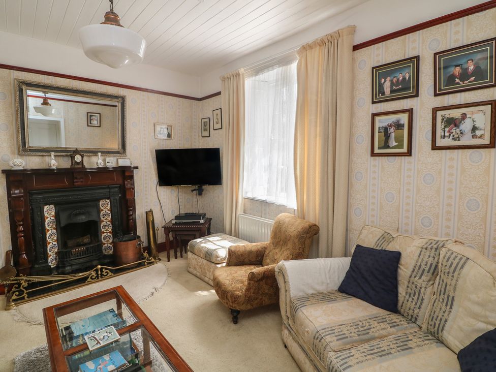 A living room with a fireplace and television at Cairbre House Dungarvan, County Waterford