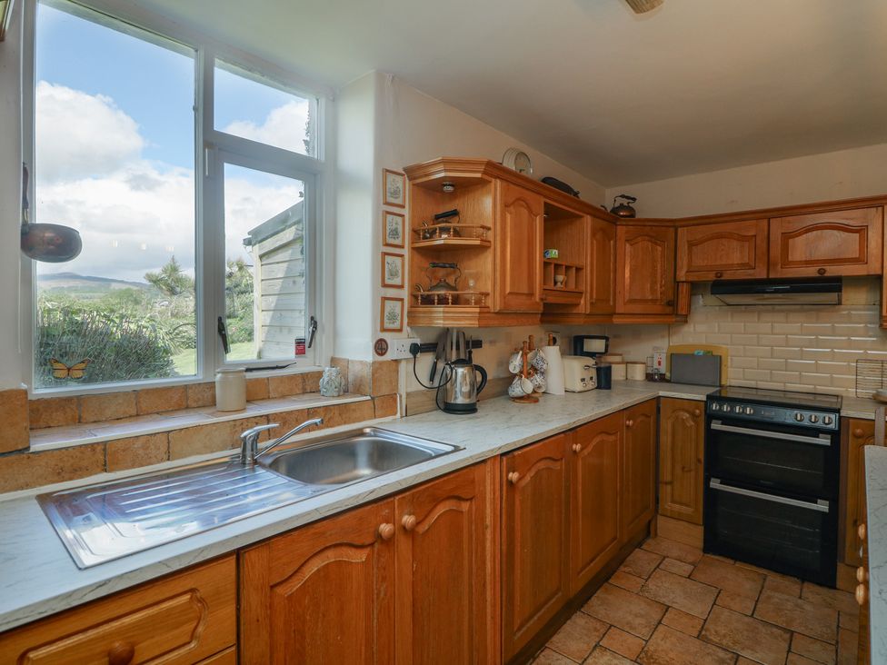 A kitchen with wooden cupboards and a window at Cairbre House in Dungarvan, County Waterford