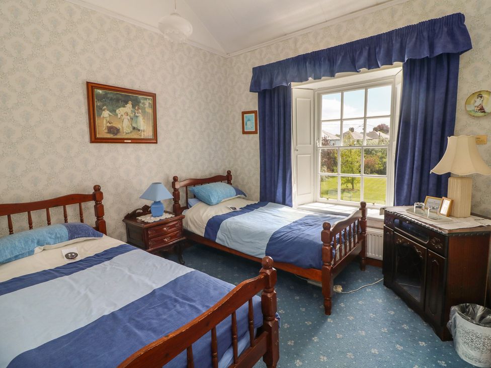 A bedroom with two beds and a window at Cairbre House in Dungarvan, County Waterford